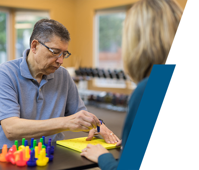 Person doing hand therapy exercises with occupational therapist