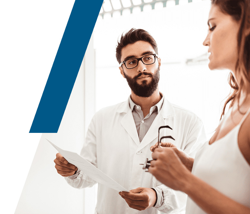Optometry clinician discussing eye care with a patient holding eyeglasses