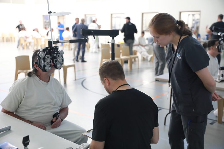 a man sitting in a chair with a woman standing next to him
