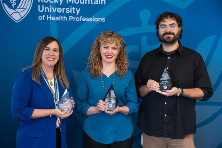 Three award recipients posing together.