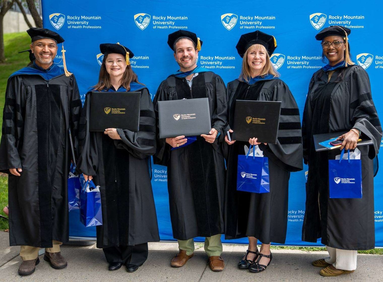 Students show their diploma covers
