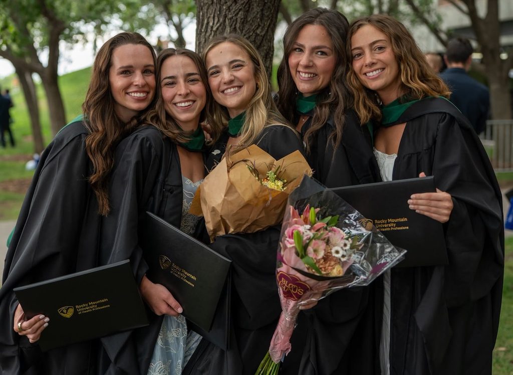 Students smile together after commencement ceremony